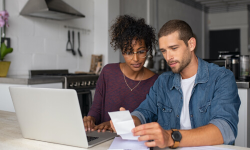 Couple looking at computer and paperwork