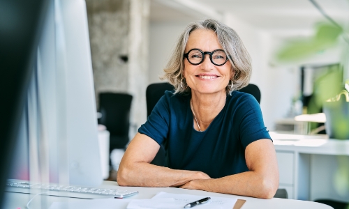 A business owner sitting at a desk and smiling