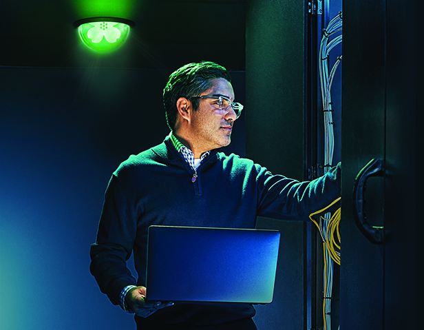 A person holding a laptop in a computer lab