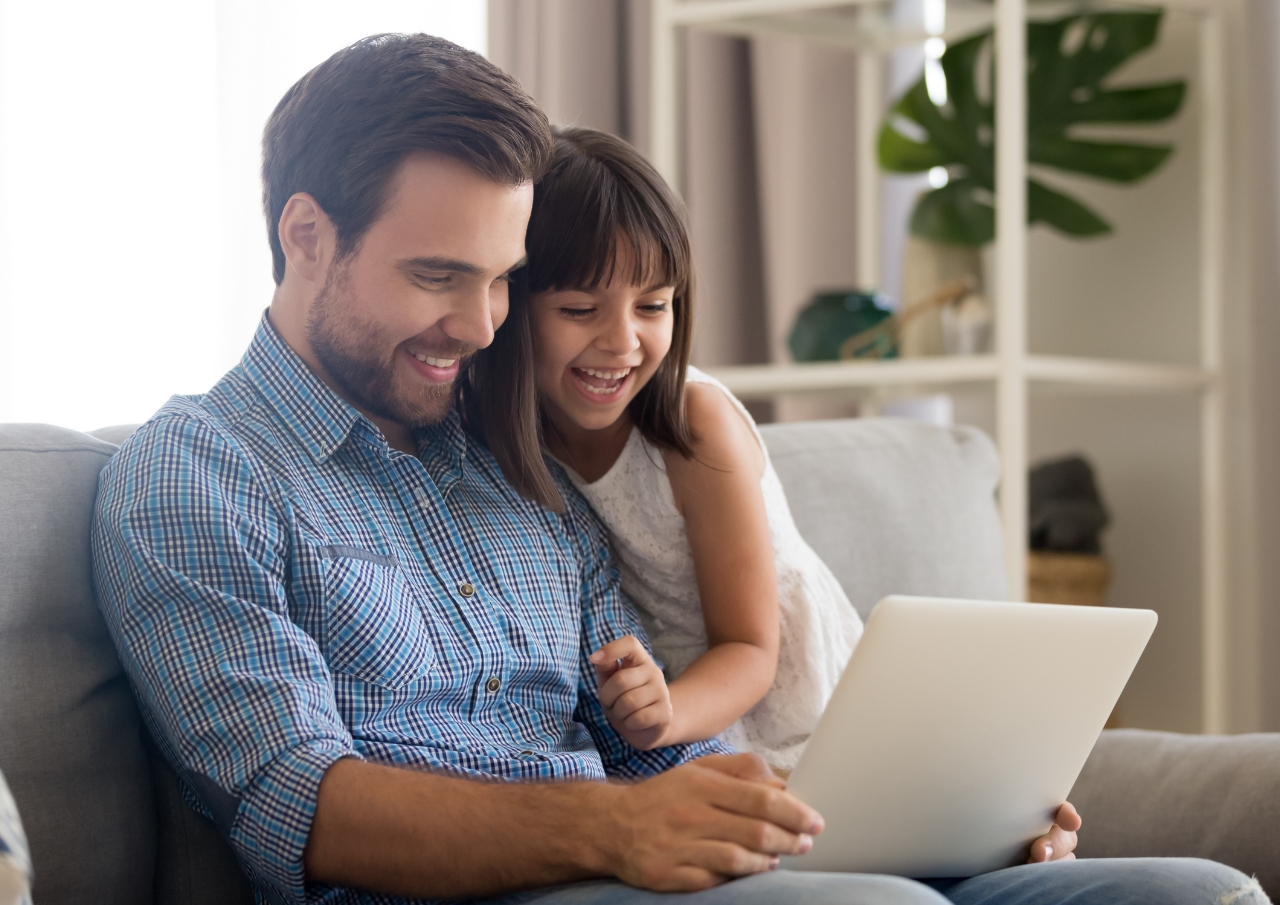 Dad and daughter working on a laptop